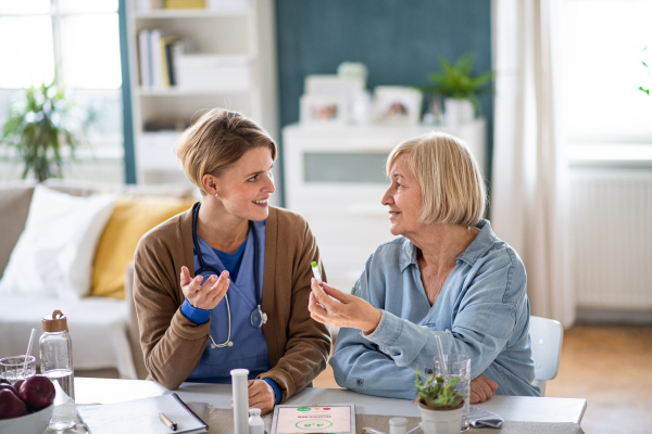 Nurse, caregiver or healthcare worker with senior woman patient, measuring blood glucose indoors.