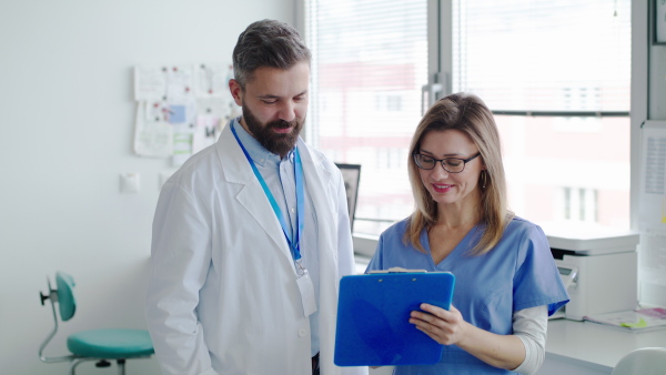 A front view portrait of dental assistant and dentist in modern dental surgery.