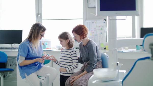 A small girl, mother and dentist in surgery, a dental checkup.