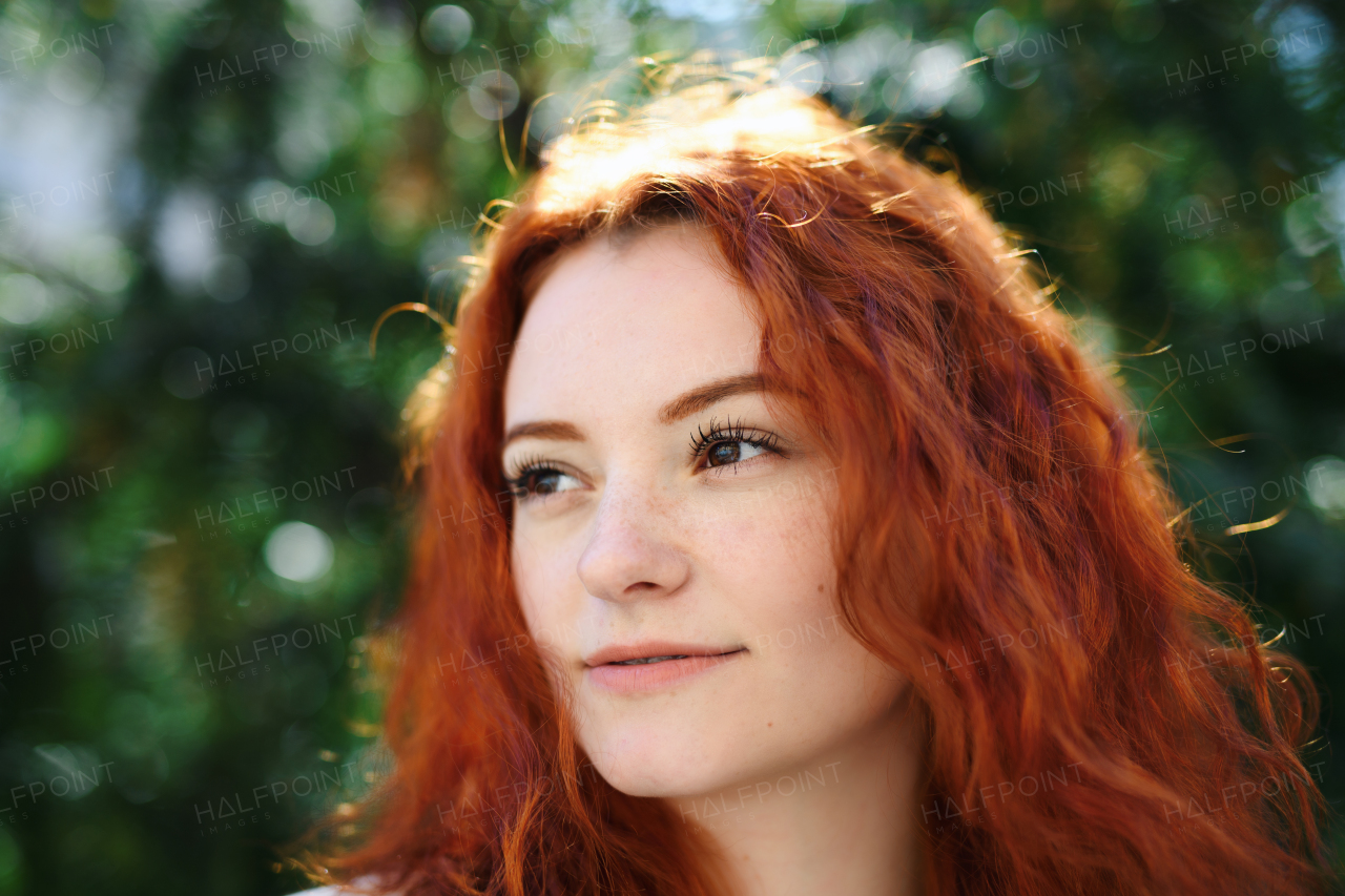 A close-up portrait of young woman outdoors in city, headshot.