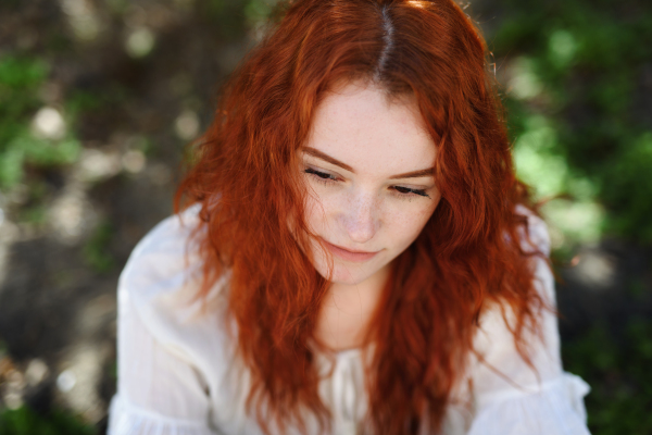 A close-up portrait of sad young woman outdoors in city.