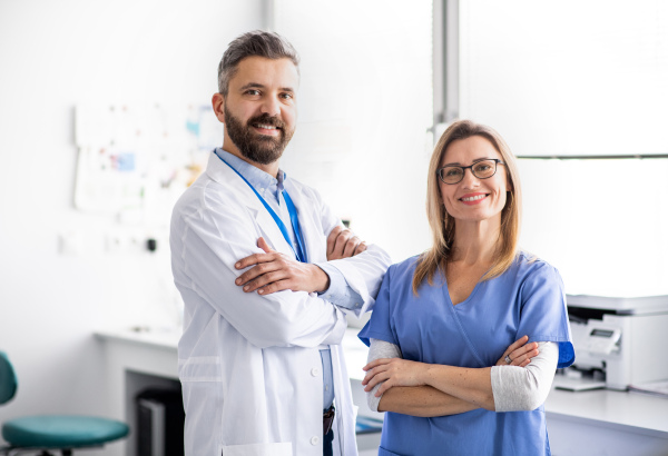 A front view portrait of dental assistant and dentist in modern dental surgery.