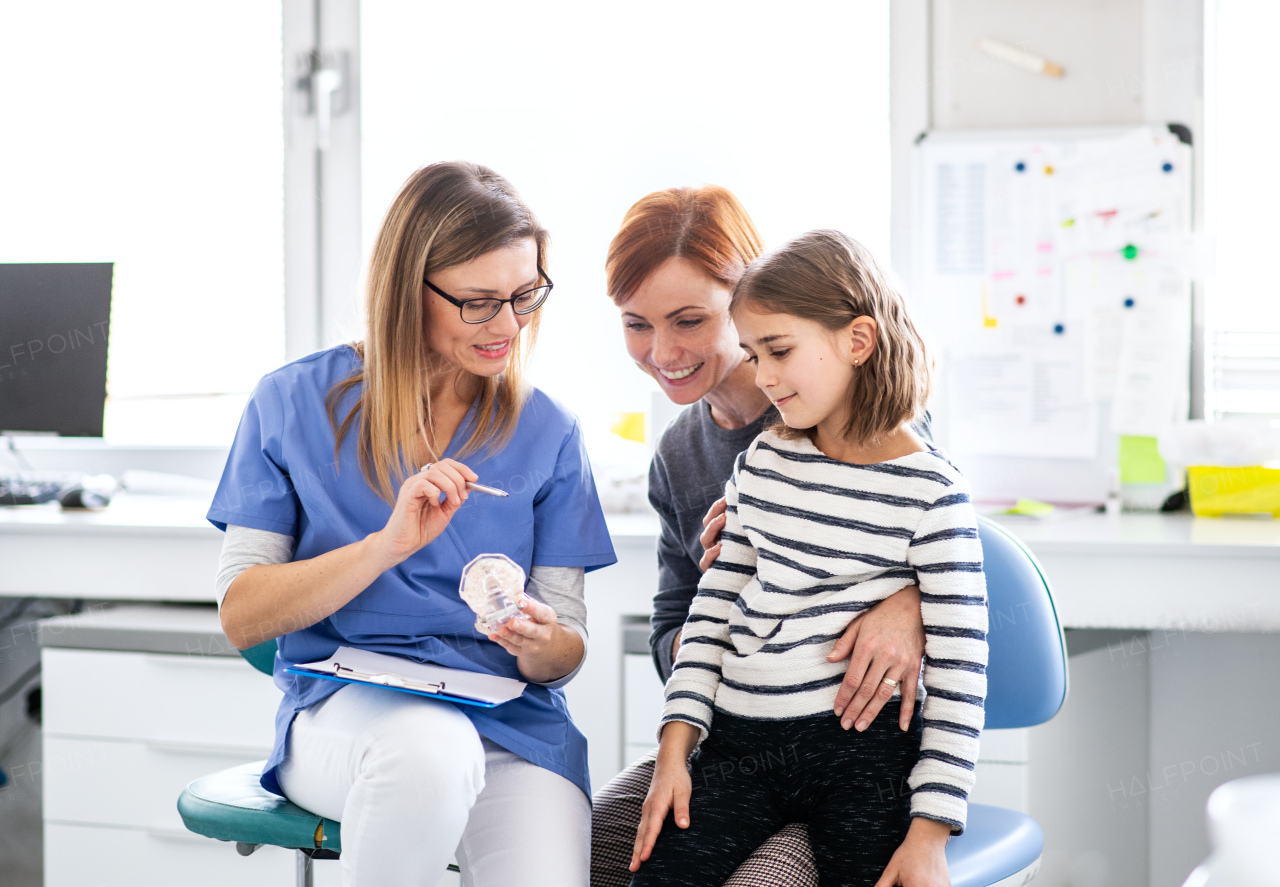 A small girl, mother and dentist in surgery, a dental checkup.