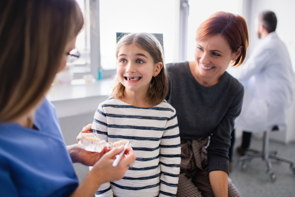 A small girl, mother and dentist in surgery, a dental checkup.