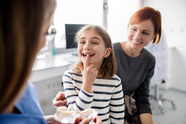 A small girl, mother and dentist in surgery, a dental checkup.