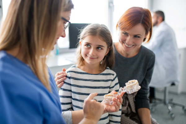 A small girl, mother and dentist in surgery, a dental checkup.