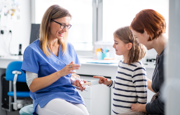 A small girl, mother and dentist in surgery, a dental checkup.