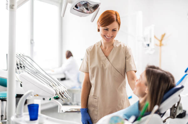 A females dentist talking to woman in dental surgery, annual check-up.