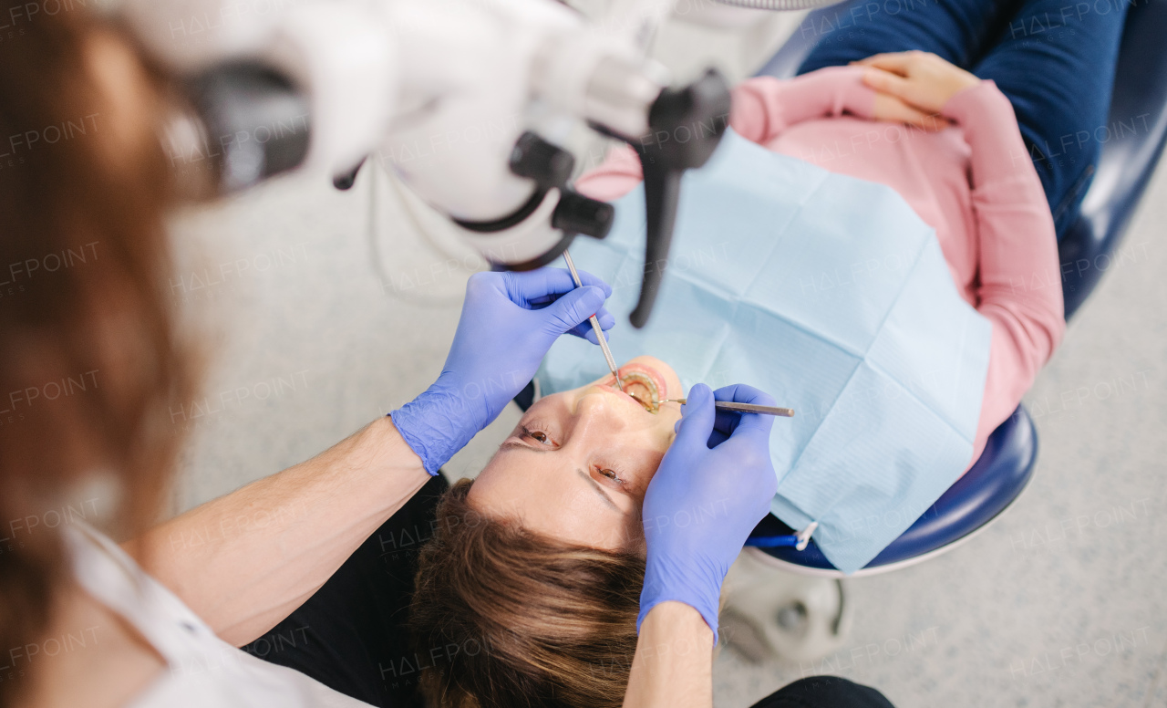 Top view of mature woman having dental check-up in dentist surgery.