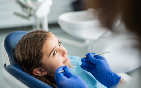 Annual dental check-up of small child girl in dentist surgery.