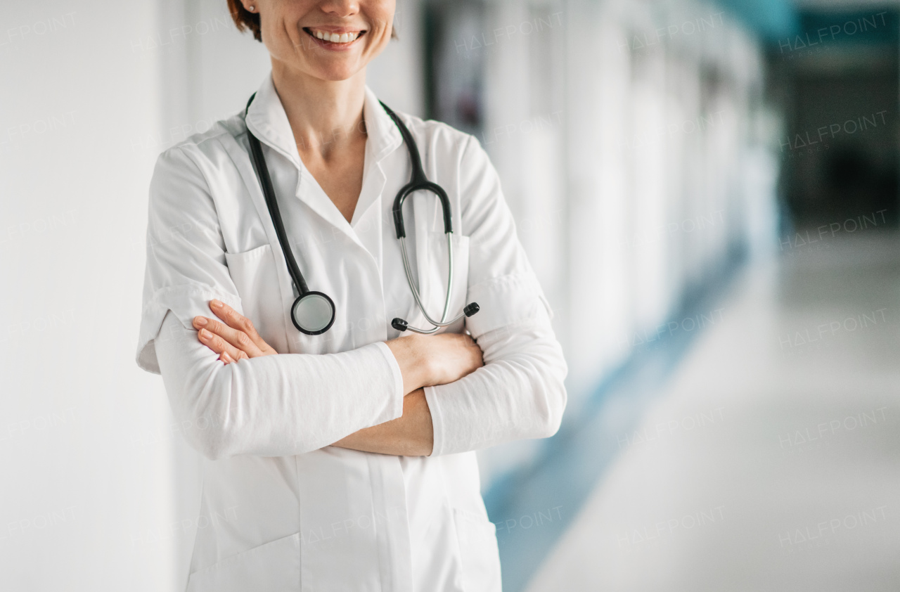 Unrecognizable woman doctor standing in hospital, arms crossed. Copy space.