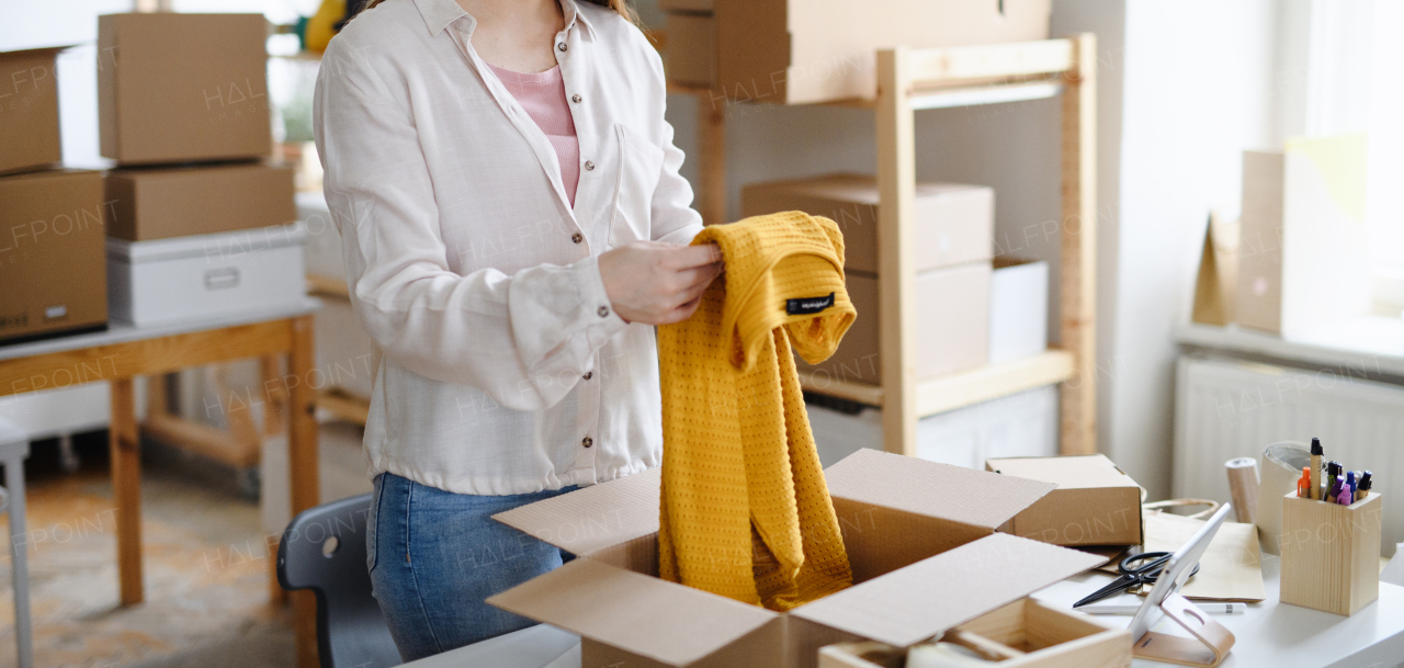 Portrait of young woman dropshipper working at home, processing orders. Coronavirus concept.