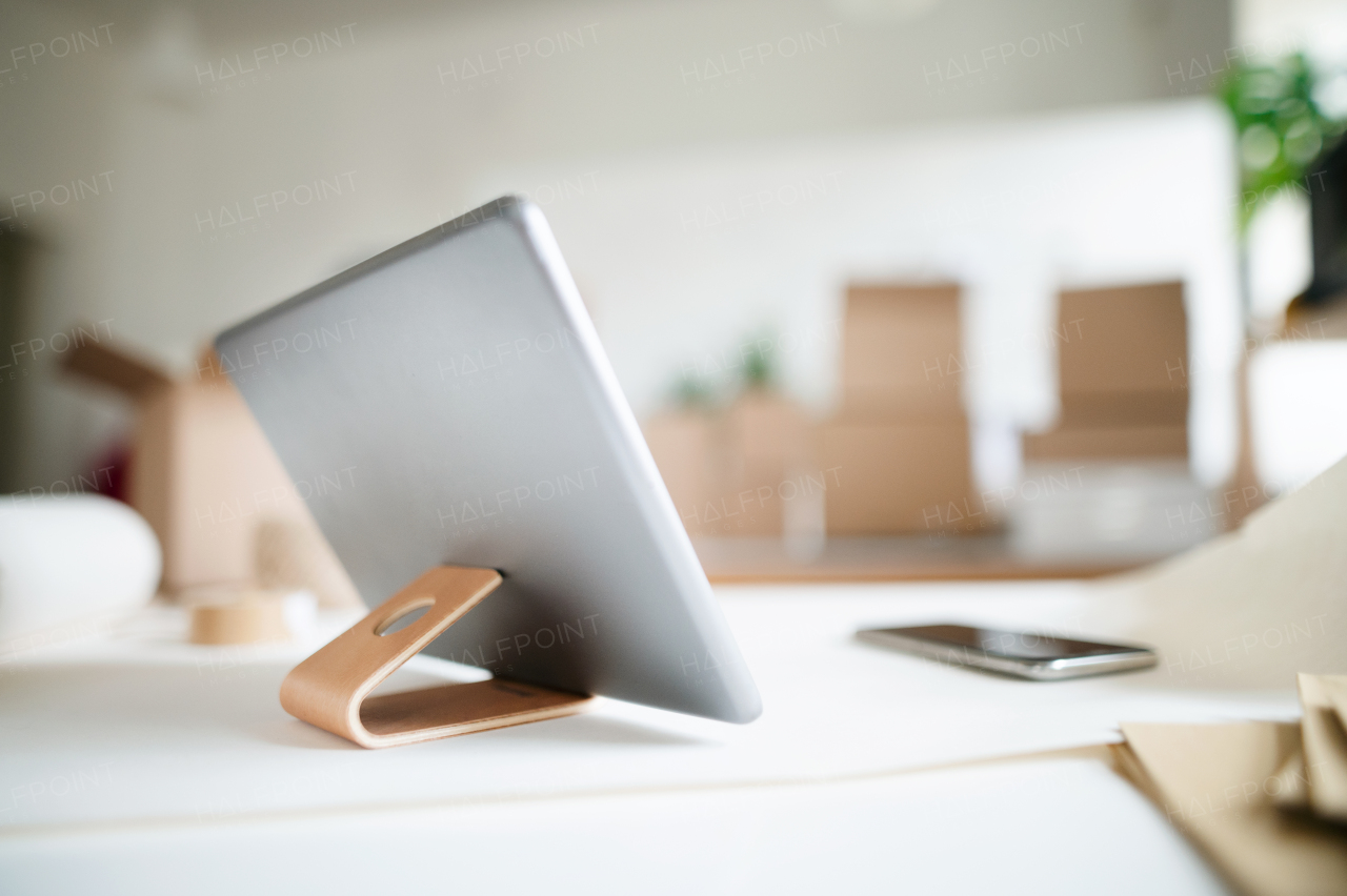 A close-up of tablet on stand on desk in office.