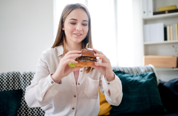 Front view of young woman with tablet ordering food at home, coronavirus and food delivery concept.