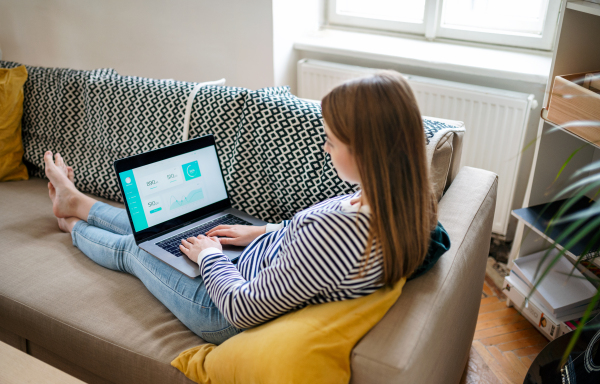 Young woman student with laptop working at home, coronavirus concept.