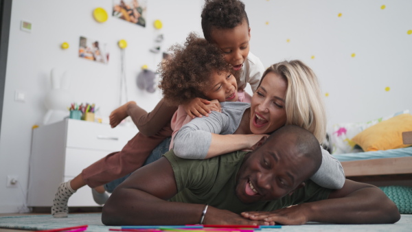 A young multiracial family lying on floor and having fun at home.