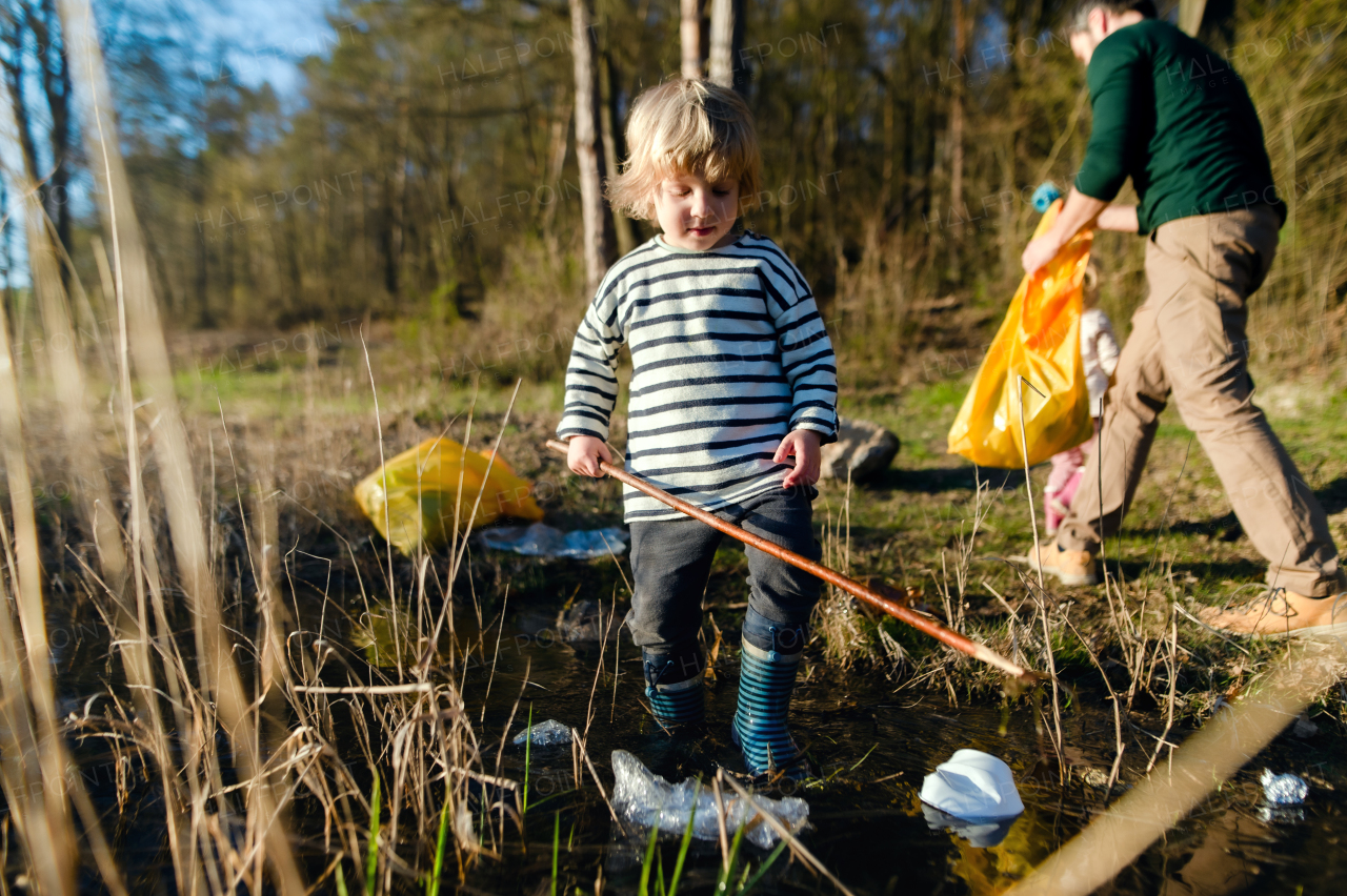 Mature father with small kids working outdoors in garden, sustainable lifestyle concept.