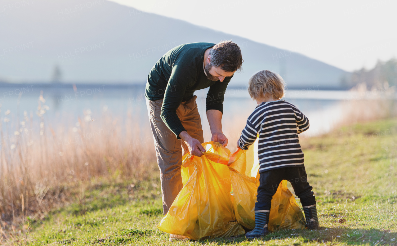 Mature father with small children working outdoors in garden, sustainable lifestyle concept.