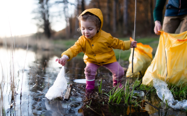 Unrecognizable father with small daughter working outdoors in garden, sustainable lifestyle concept.