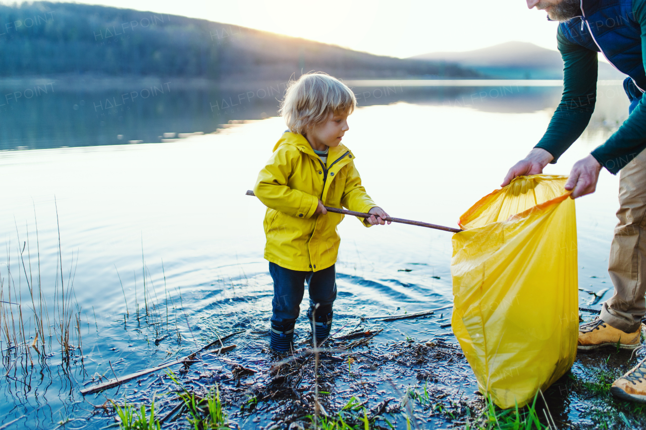 Mature father with small children working outdoors in garden, sustainable lifestyle concept.