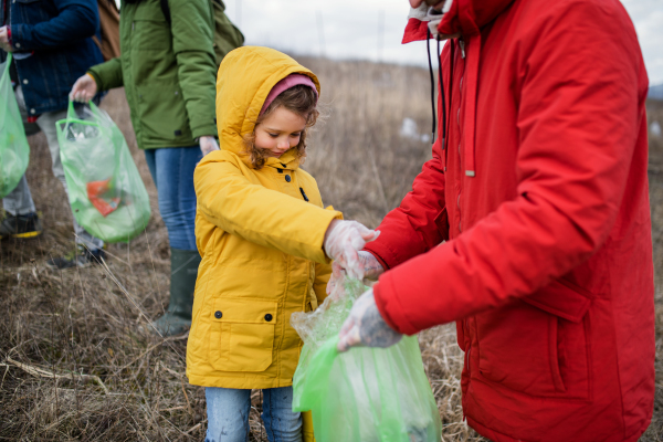 Group of activists picking up litter in nature, environmental pollution and plogging concept.