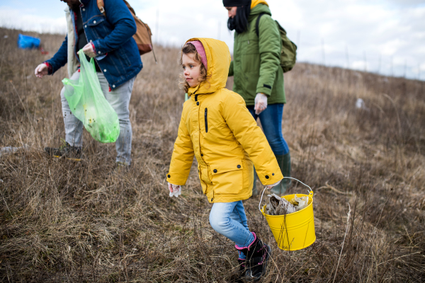 Group of activists picking up litter in nature, environmental pollution and plogging concept.