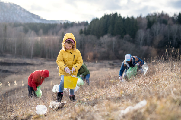 Group of activists picking up litter in nature, environmental pollution and plogging concept.