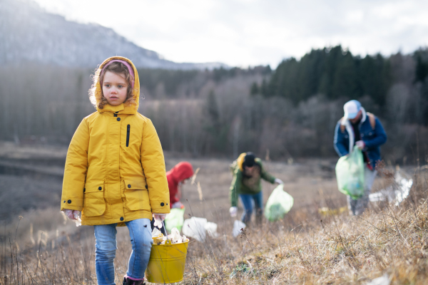 Group of activists picking up litter in nature, environmental pollution and plogging concept.