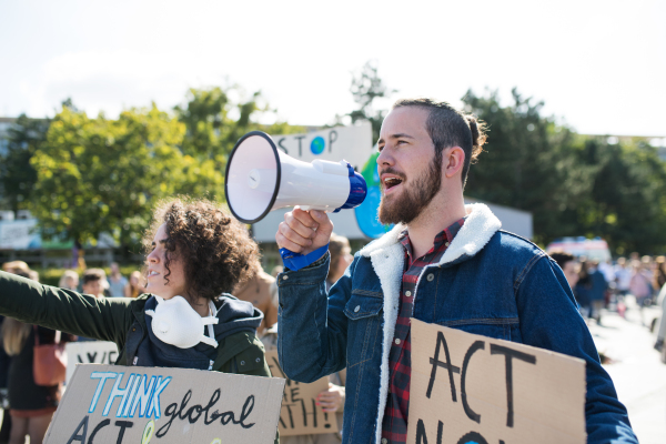 A man with placards and amplifier on global strike for climate change, shouting.