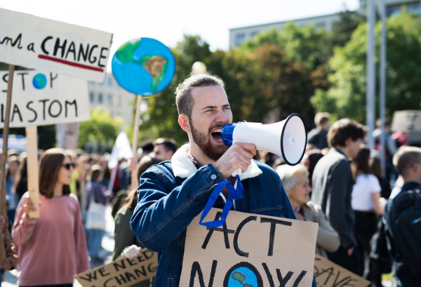 A man with placards and amplifier on global strike for climate change, shouting.