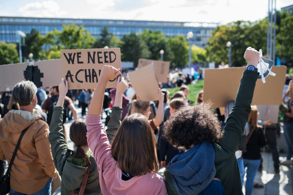 A rear view of people with placards and posters on global strike for climate change.