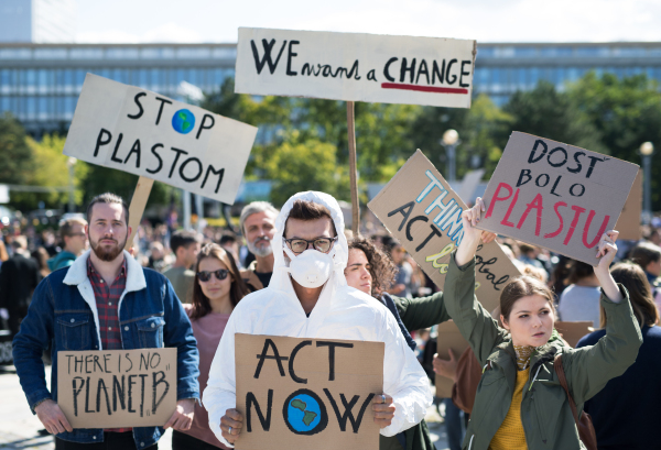 A people with placards and protective suit on a global strike for climate change.