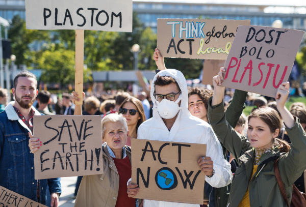 A people with placards and protective suit on a global strike for climate change.