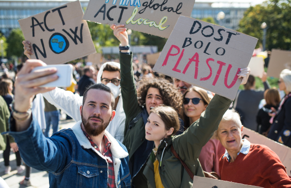 People with placards and posters on a global strike for climate change, taking selfie.