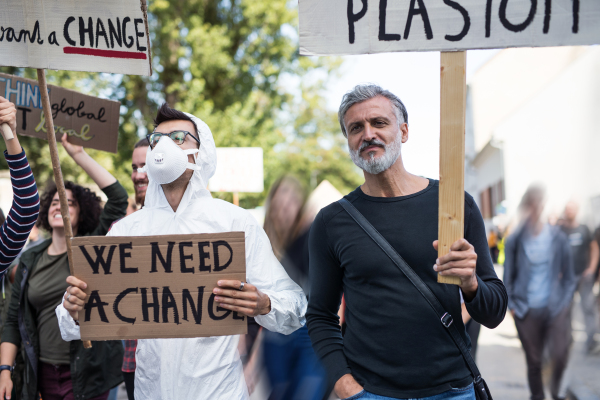 A people with placards and protective suit on a global strike for climate change.