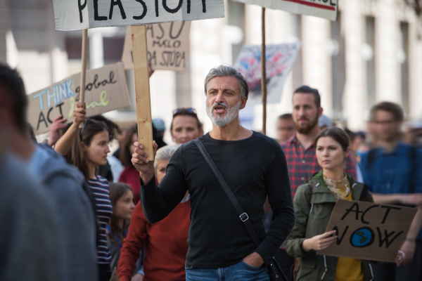 A people with placards and protective suit on a global strike for climate change.