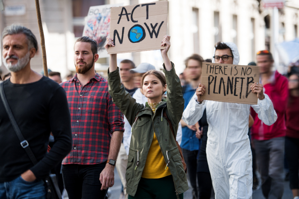 People with placards and a protective suit on a global strike for climate change.