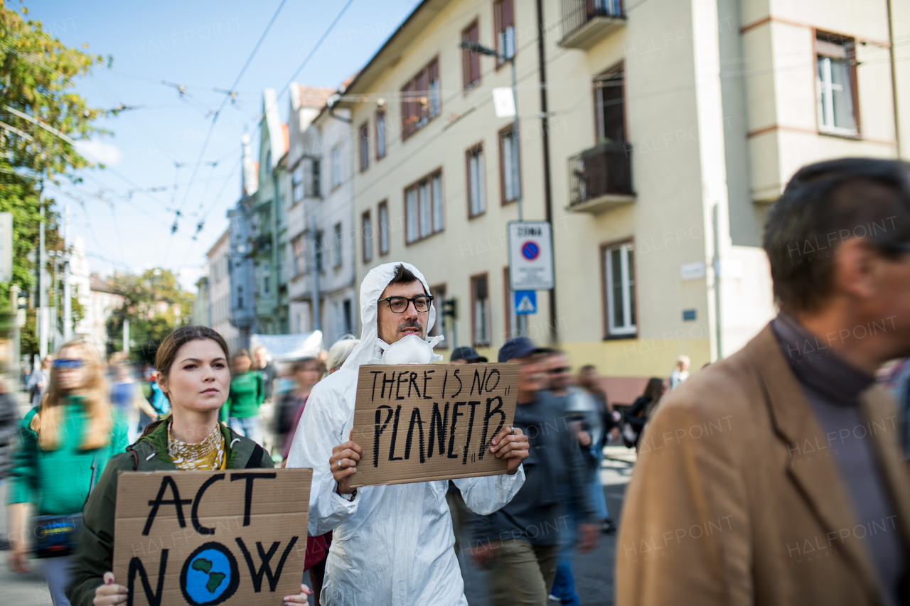 People with placards and a protective suit on a global strike for climate change.