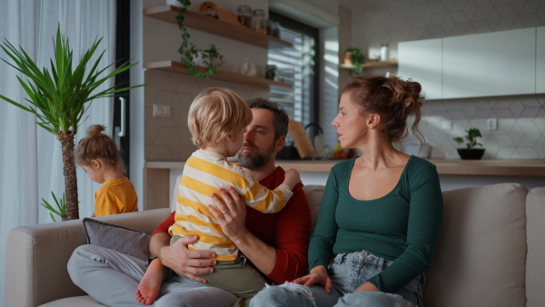 Little children bonding with parents on a sofa at home