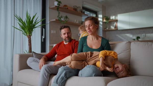 Little children bonding with parents on a sofa at home