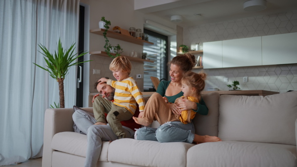 Little children bonding with parents on a sofa at home