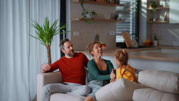 Little children bonding with parents on a sofa at home