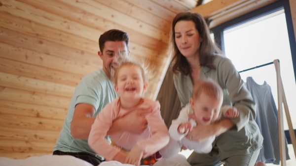 A happy young family with small children having fun in cabin on holiday.