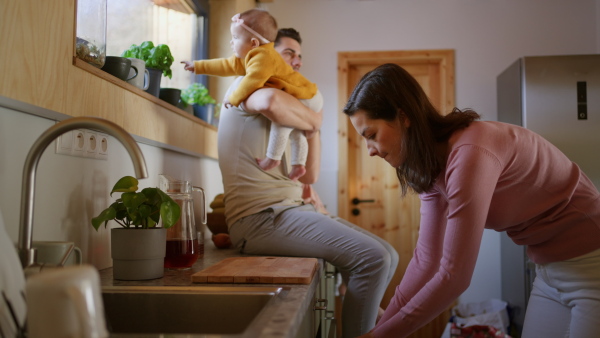 A happy young family with small children cooking together in cabin on holiday.