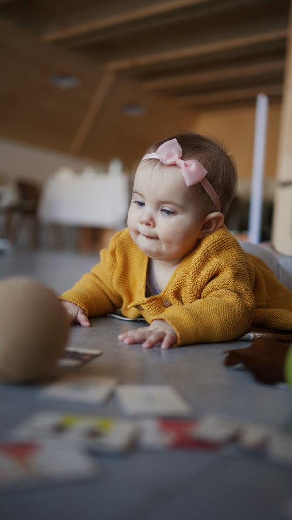 A vertical footage of little baby lying on floor and playing.