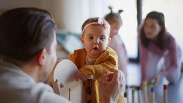 A happy young family with small children playing at home.