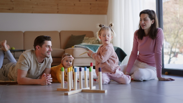 A happy young family with small children playing at home.