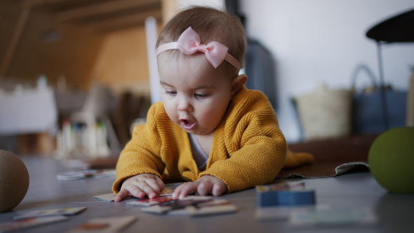 A little baby lying on floor and playing.