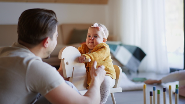 A young father enjoying time together with baby girl at home.