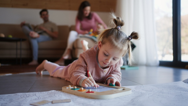 A happy young family with small children playing at home.